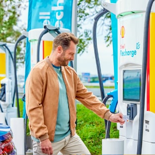 Man using phone at a Shell Recharge Station