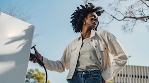 A woman at an EV charger