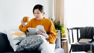Woman with coffee reading on the couch