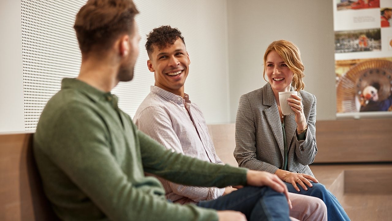 Three colleagues are in a conversation
