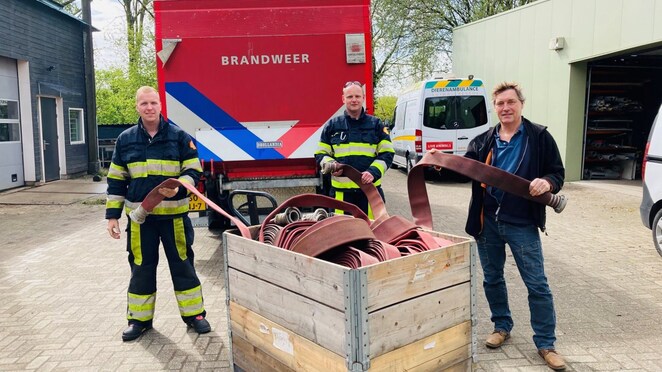 Yoran van Meeuwen en Martien de Witte overhandigen David van Gennep, directeur van Stichting AAP, de brandweerslangen van Shell Pernis.