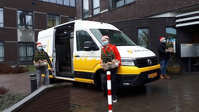 Celina voor de bus: Medewerkers delen vanuit de Shell on Tour bus de boompjes uit.
