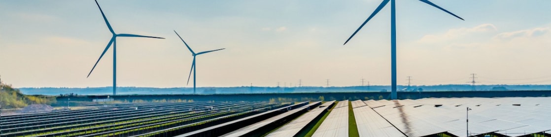 De foto toont drie windturbines en een zonnepark in het Nederlandse landschap
