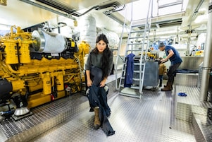 In oude schepen was een machinekamer vaak één grote vette  bende. Het was lawaaiig, en krap ook. Nu ziet het er brandschoon uit, de motoren zitten goed in de gele verf, de dikke bouten glimmen in het kunstlicht.