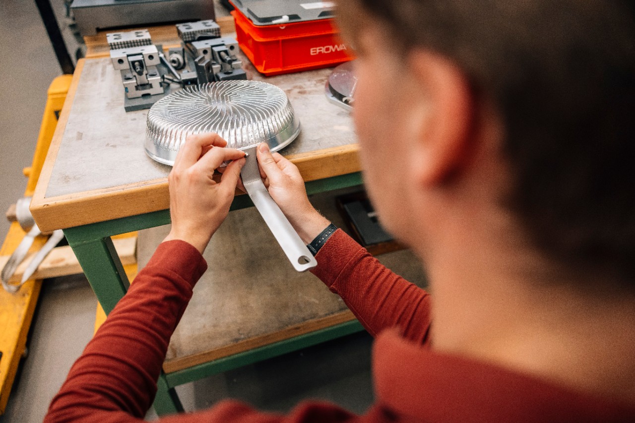 Een medewerker checkt de schroef die de steel aan de Effium-pan vastmaakt.