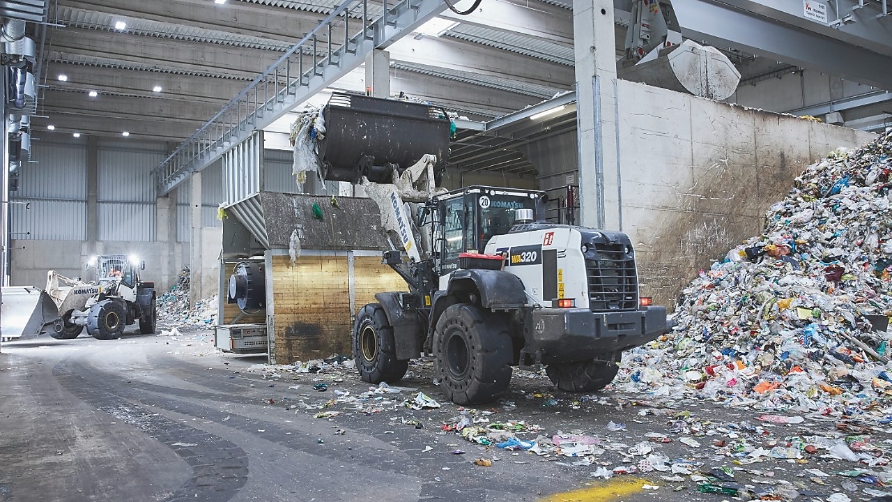 Een kleine bulldozer verplaatst plastic afval. Heel divers plastic afval gaat met zwaar materieel naar de installatie om  gesorteerd te worden. (Foto: Remondis Recycling)