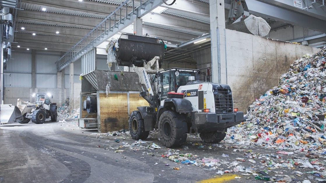 Een kleine bulldozer verplaatst plastic afval. Heel divers plastic afval gaat met zwaar materieel naar de installatie om  gesorteerd te worden. (Foto: Remondis Recycling)