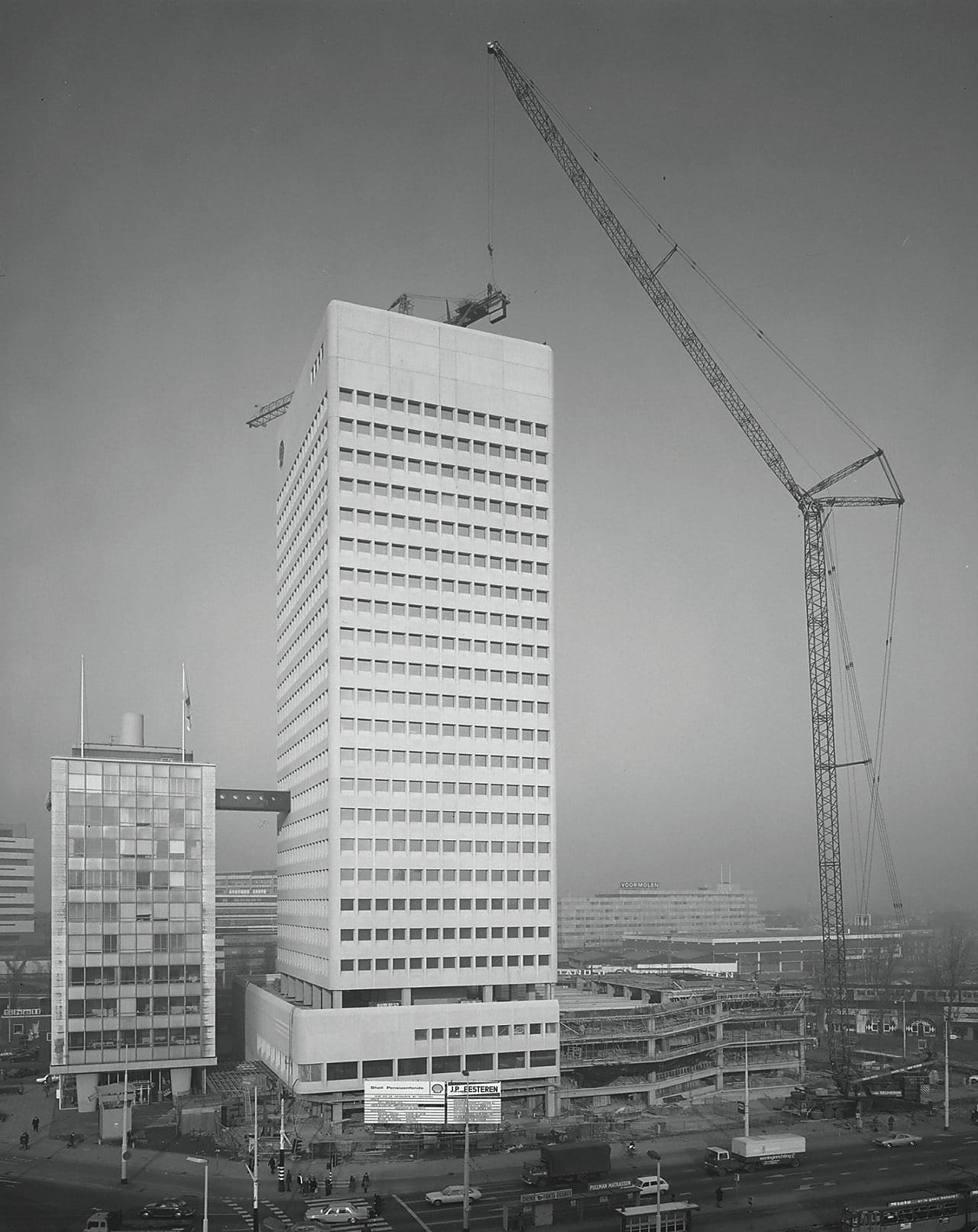 November 1975 – de in aanbouw zijnde  Shell-toren aan het Hofplein met rechts de nieuwe  parkeergarage. Rond de 7e etage de wandelverbinding met het eerste Shell-gebouw (Foto: Stadsarchief Rotterdam)