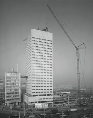 November 1975 – de in aanbouw zijnde  Shell-toren aan het Hofplein met rechts de nieuwe  parkeergarage. Rond de 7e etage de wandelverbinding met het eerste Shell-gebouw (Foto: Stadsarchief Rotterdam)