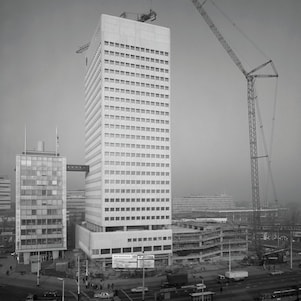 November 1975 – de in aanbouw zijnde  Shell-toren aan het Hofplein met rechts de nieuwe  parkeergarage. Rond de 7e etage de wandelverbinding met het eerste Shell-gebouw (Foto: Stadsarchief Rotterdam)