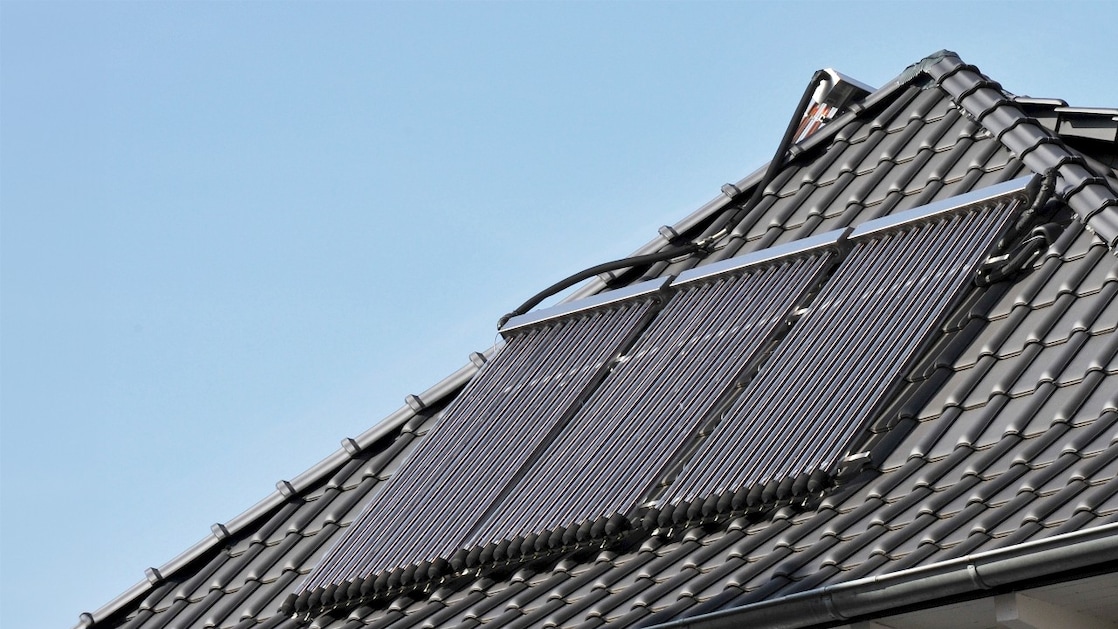 Zonnepanelen op het dak van een woonhuis, om met de stroom warm water te maken