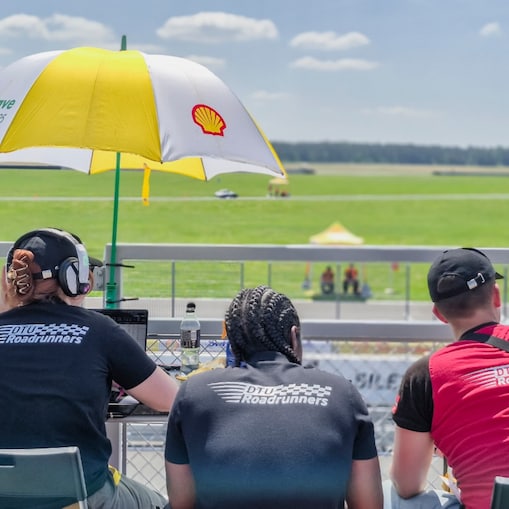 Drie leden van een Deens team bekijken de voortgang van hun wagen vanaf een hoger gelegen positie. (Foto: Marcel Burger)