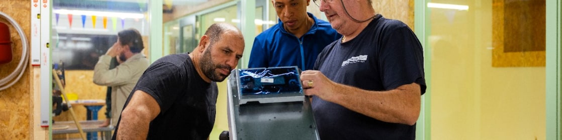 Een leermeester legt uit aan twee volwassen leerlingen bij De Beroepentuin (Foto: Christian Kalse)