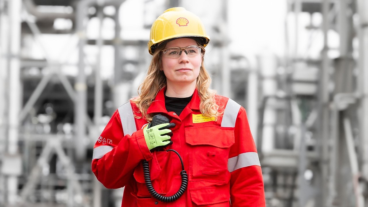 Tineke van Paassen bij de fabriek op Shell Chemicals Park Moerdijk