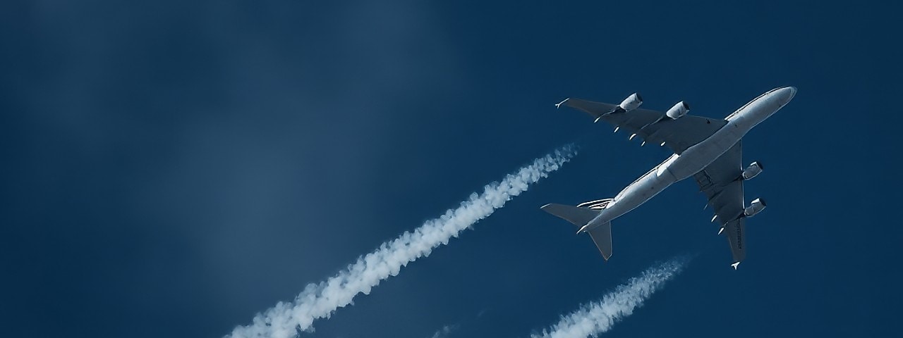 Een vliegtuig met condensatiestrepen (Foto: Adobe Stock)