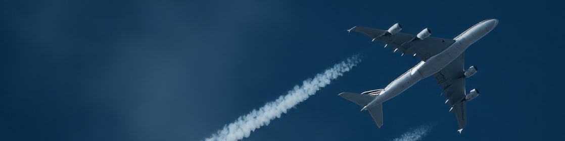 Een vliegtuig met condensatiestrepen (Foto: Adobe Stock)