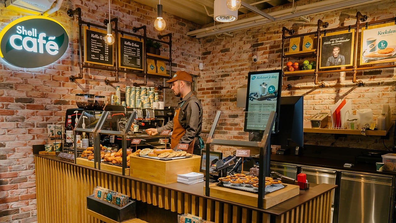 Een barista bij de koffiemachine van een van de Nederlandse Shell Cafés in 2021 (Foto: Shell Nederland)