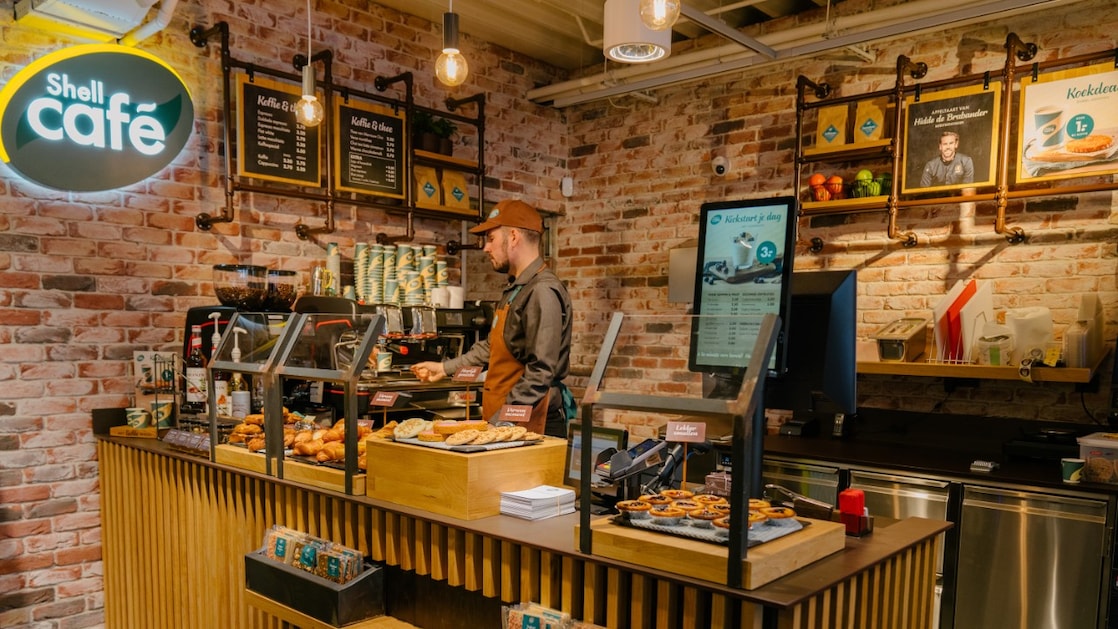 Een barista bij de koffiemachine van een van de Nederlandse Shell Cafés in 2021 (Foto: Shell Nederland)