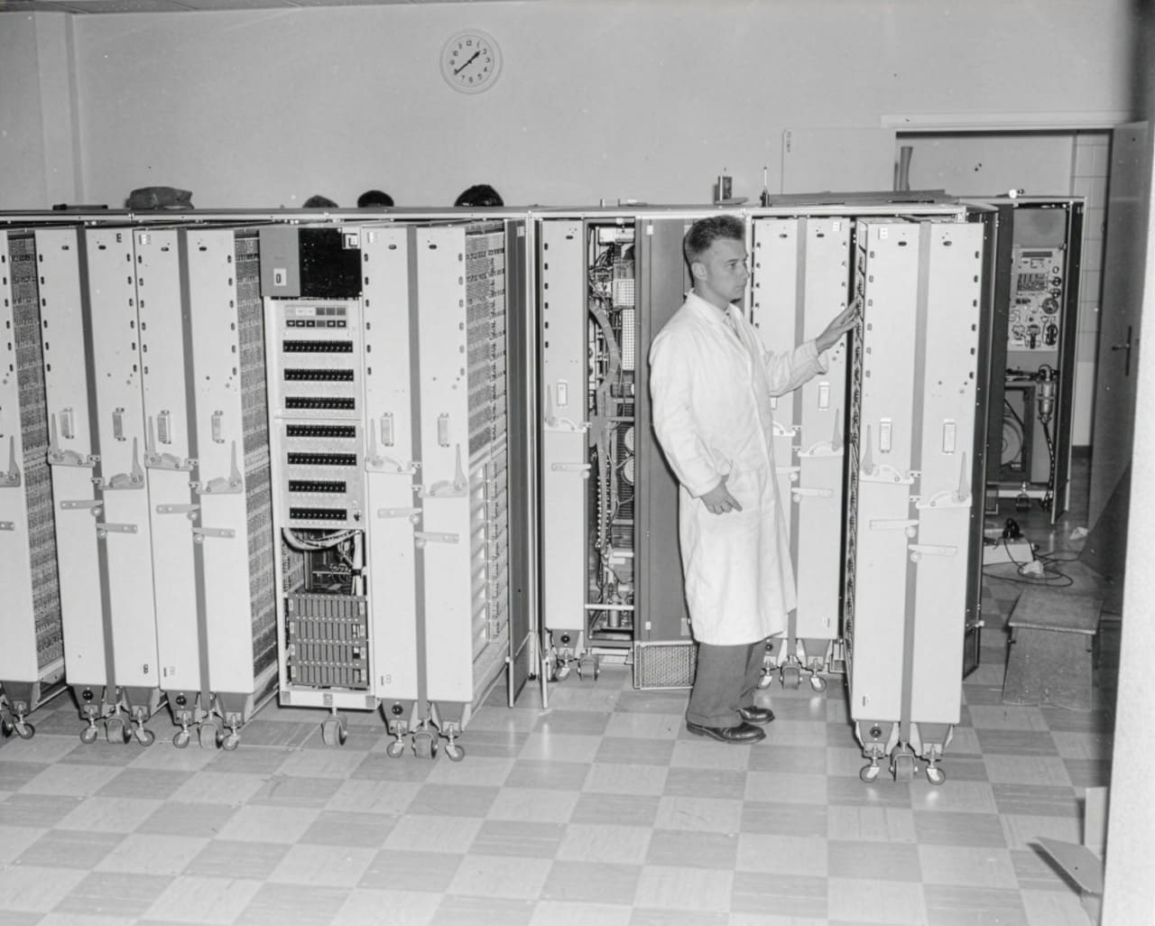 Een operator met witte jas bij kasten vol elektronica, Shell Den Haag, begin jaren 60 (Foto: Shell Heritage & Historical Archive)