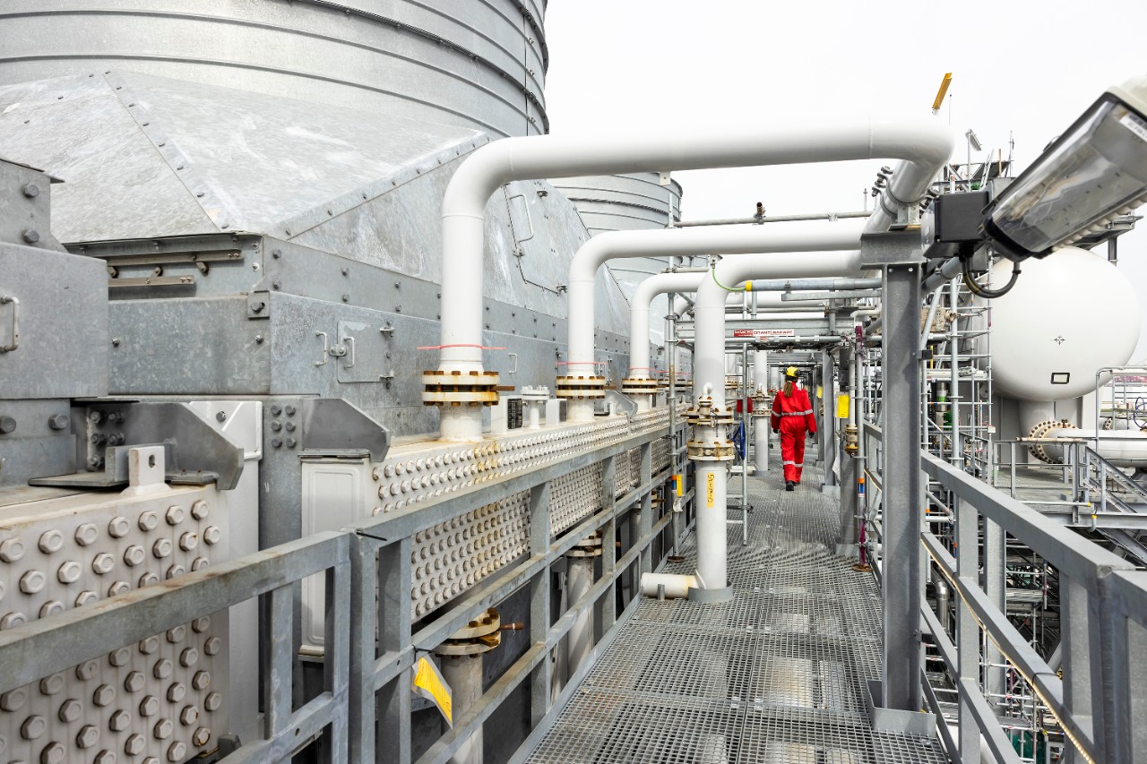 Een medewerker loopt door een van de installaties van Holland Hydrogen 1, april 2026 (Foto: Christian Kalse)