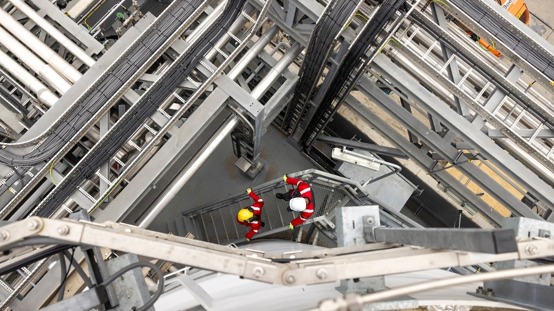 Two employees walking down the stairs of the Holland Hydrogen 1, April 2026 (Photo: Christian Kalse)