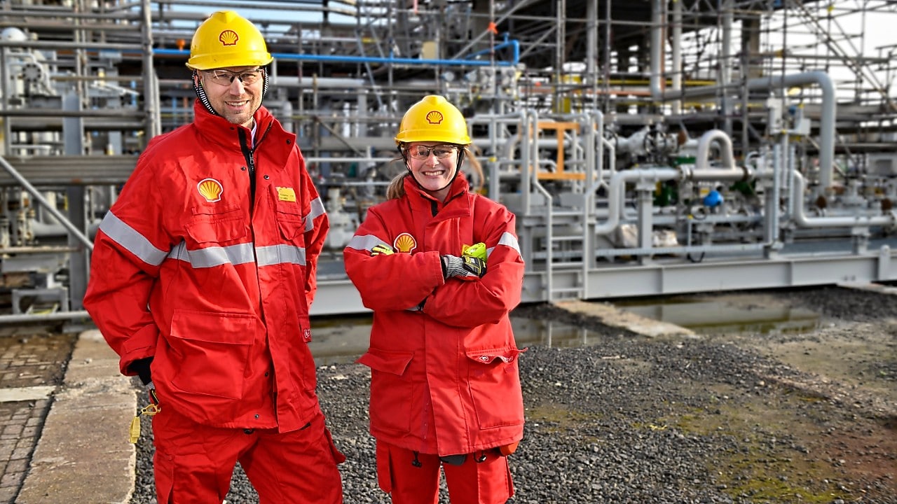 Thijs Bosboom van Holland Hydrogen 1 en Vera Wissel van Shell Pernis bij de installatie waar de groene waterstof straks op Pernis aankomt (Foto: Ernst Bode)