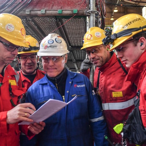 Vier Shell-ers en een aannemer bekijken het plan van aanpak van een deel van de turnaround, april 2026 (Foto: Ernst Bode)