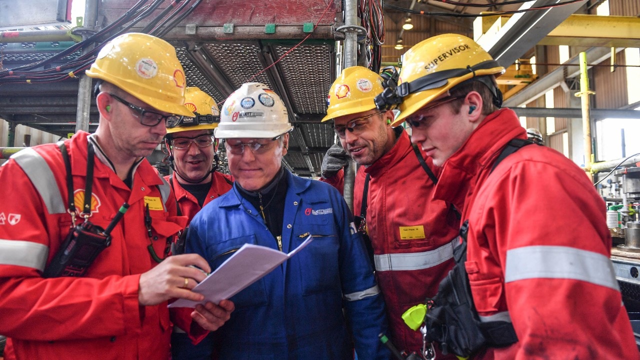 Four Shellonians and a contractor look at the plan for part of the turnaround, April 2026 (Photo: Ernst Bode)