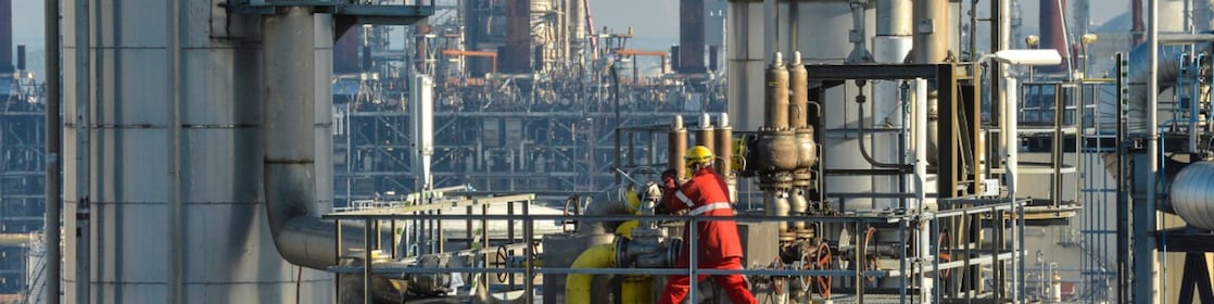 Een medewerker draait aan een groot wiel op een van de fabrieken van Shell Chemicals Park Moerdijk (Foto: Ernst Bode)