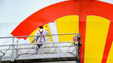De Shell-pecten wordt op een opslagtank in Rotterdam geverfd
