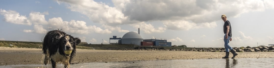 Een hond en een wandelaar op het strand bij de kerncentrale van Borssele (Foto: ANP/Hollandse Hoogte/Manon Bruininga)