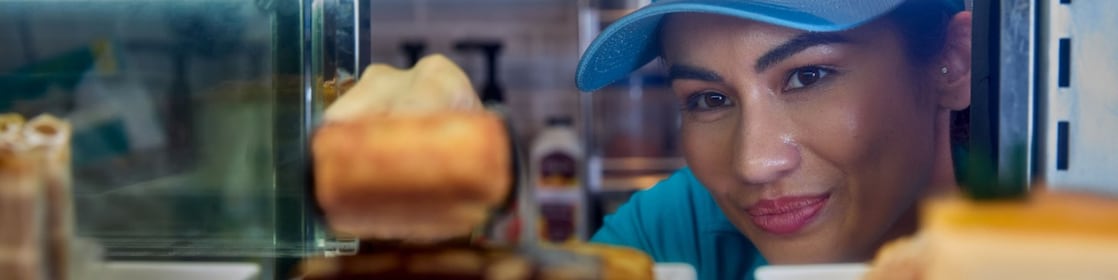 Een Shell-barista kijkt in de cake-vitrine van het Shell Café (Foto: GED Films Ltd.)
