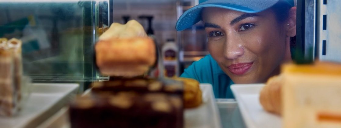 Een Shell barista looks into the cake supply of a Shell Café (Foto: GED Films Ltd.)