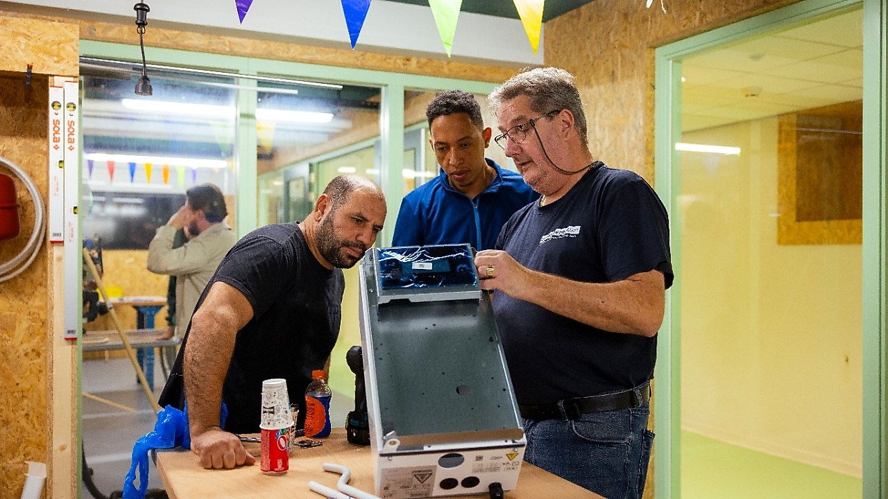Een leermeester legt uit aan twee volwassen leerlingen bij De Beroepentuin (Foto: Christian Kalse)