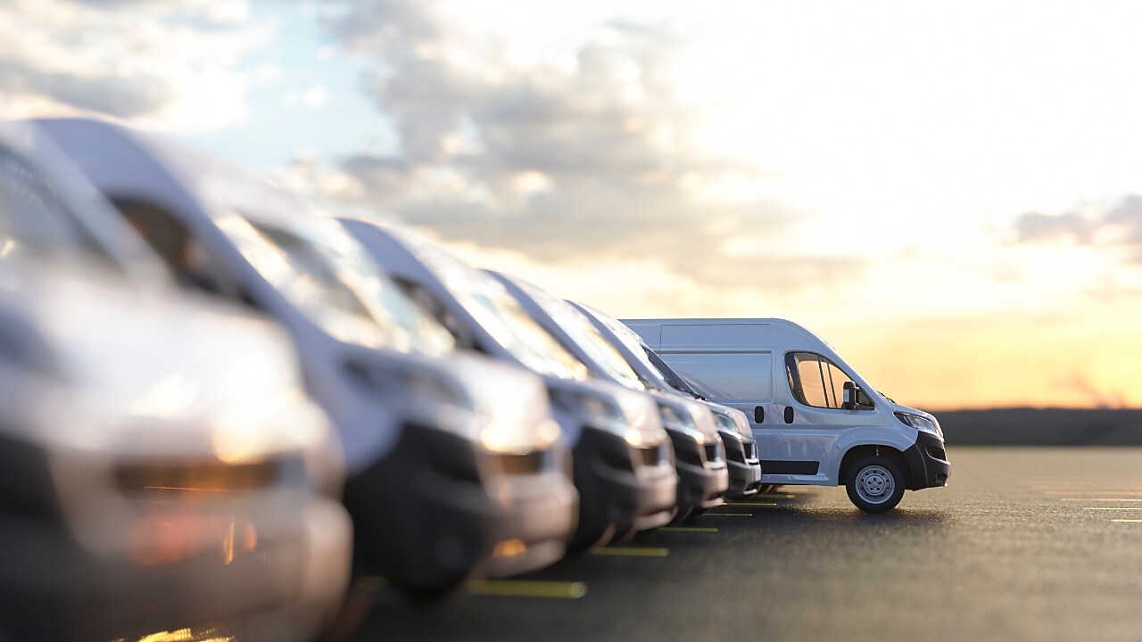 En rij witte bestelbusjes