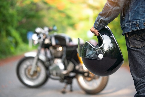 Een motorrijder houdt zijn helm vast.
