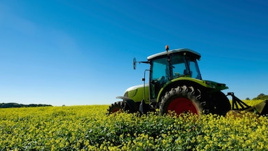 Een tractor op het land op een zonnige dag