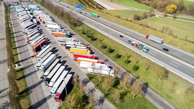 Vrachtwagens op een parkeerplaats bij de snelweg. Luchtfoto.