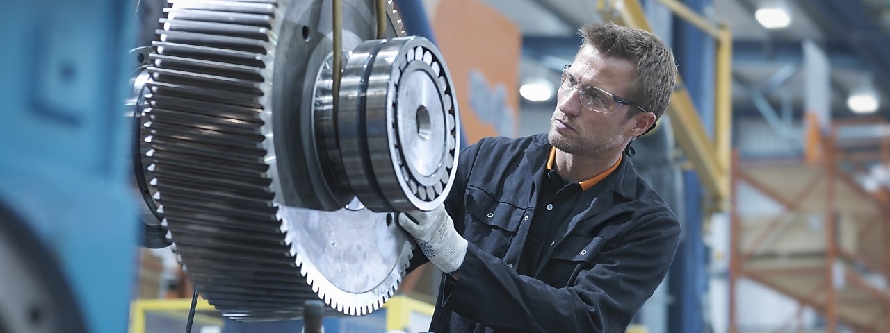 Een techneut bekijkt een groot tandwiel