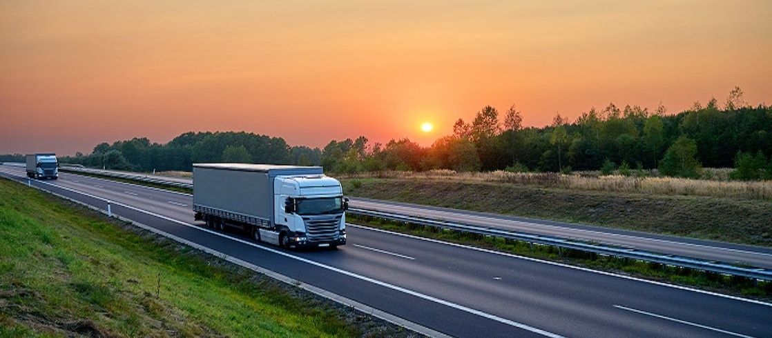 Trucks on a highway at sunset