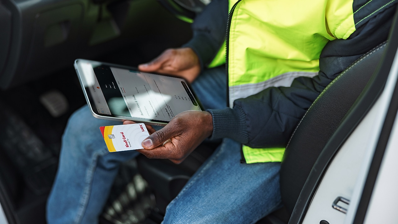 Chauffeur houdt Shell Card naast tablet voor overzicht