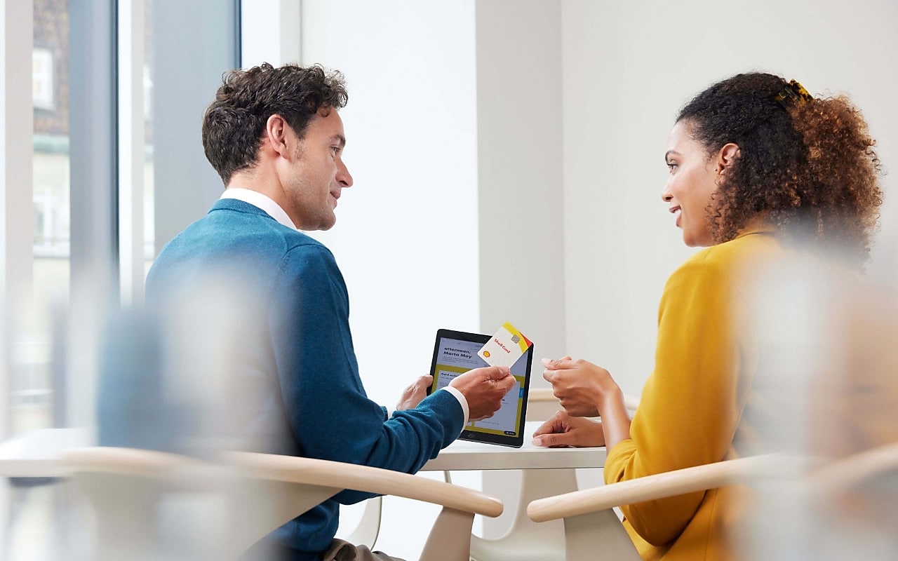 Man geeft vrouw Shell Card op kantoor