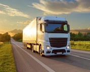 Een witte vrachtwagen op een provinciale weg.