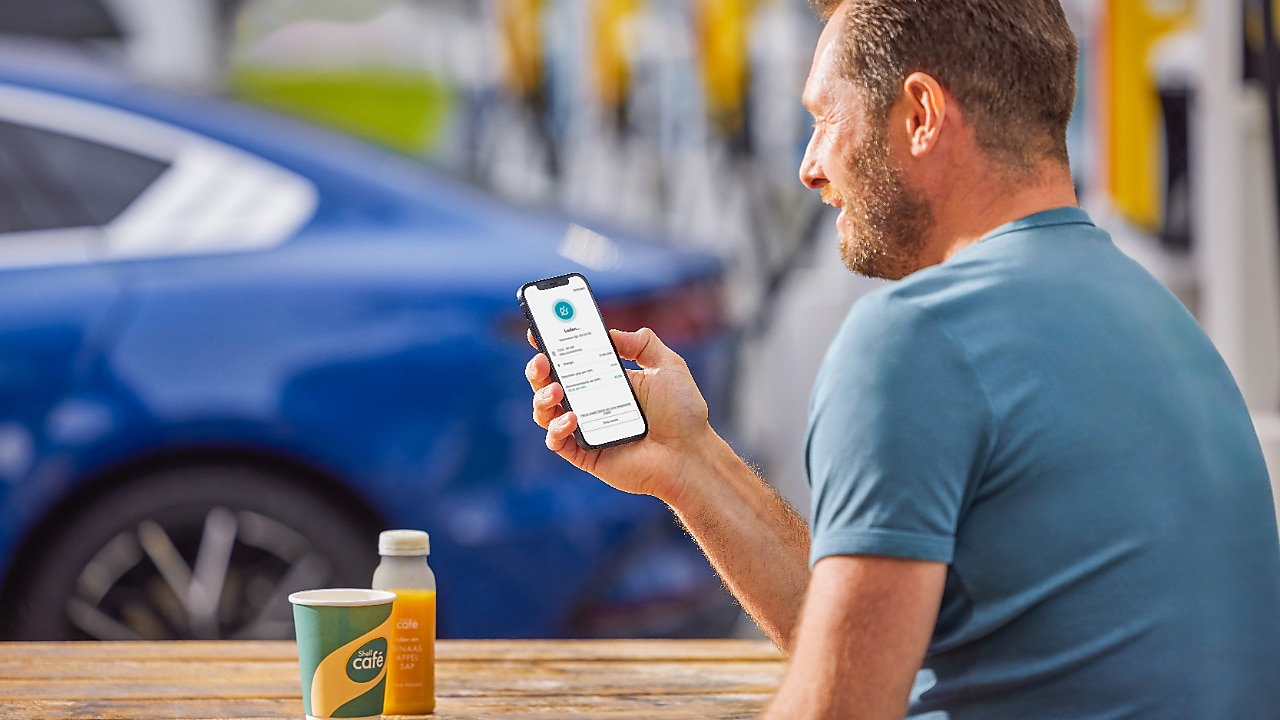 Man using phone at a Shell Recharge Station