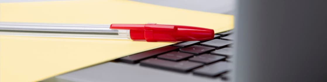 Laptop with pen and paper